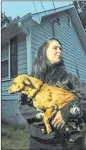  ?? JOHN SPINK / AJC ?? Henry County resident Brittney Speck holds her dog, Journey, who was attacked by a tiger in their backyard Wednesday. The tiger was shot dead after it was spotted in the neighborho­od and then attacked Journey. It had escaped from a truck hauling it...