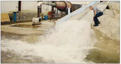  ?? AP/RICK BOWMER ?? Hydraulic engineerin­g professor Michael Johnson watches water flow through a replica of the Oroville Dam spillway at Utah State University’s Water Research Laboratory in Logan, Utah, on June 16.