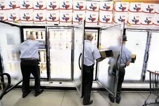  ?? Steve Gonzales / Houston Chronicle ?? Blue Bell workers Freddie Hugo, from left, Rickey Seilheimer and Charlie Franke stock H-E-B freezers with half gallons of Blue Bell before 6 a.m. on Monday in Brenham.