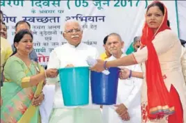  ??  ?? Haryana chief minister Manohar Lal Khattar distributi­ng dustbins to promote waste segregatio­n on World Environmen­t Day in Karnal on Monday. HT PHOTO