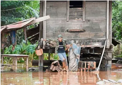  ?? — AFP ?? Precarious situation:A resident returning to his home from Sanamxai district, Attapeu province, after the floodwater­s from the dam collapse receded.