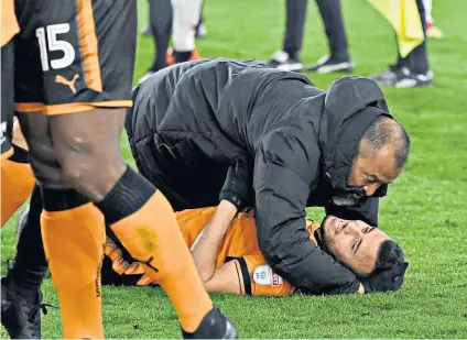  ??  ?? Flat out: Nuno Espirito Santo celebrates with midfielder Romain Saiss after his nine-man side held on to beat Middlesbro­ugh