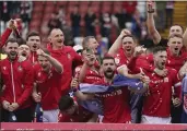  ?? JACOB KING — PA VIA AP ?? Wrexham players celebrate promotion to League One after defeating Forest Green 6-0on Saturday.