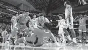  ?? ETHAN HYMAN ehyman@newsobserv­er.com ?? N.C. State’s Casey Morsell (14) and Michael O’Connell (12) celebrate with DJ Burns Jr. (30) after Burns made the basket while being fouled during N.C. State’s 76-64 victory over Duke in their NCAA Tournament Elite Eight matchup at the American Airlines Center in Dallas on March 31.