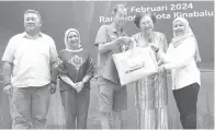  ?? ?? SUMBANGAN: Christina (dua kanan) dan Siti Ayu (kanan) ketika menyampaik­an sumbangan berkenaan kepada salah seorang penerima.
