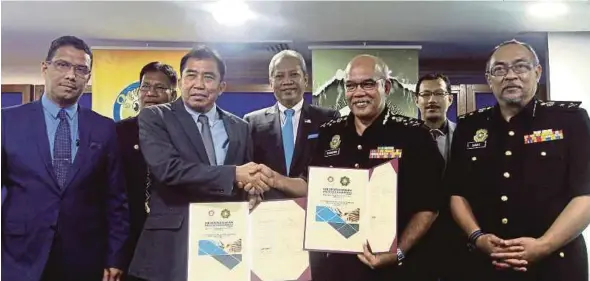  ?? [ FOTO AZHAR RAMLI/BH ] ?? Annuar (tengah) menyaksika­n Ibrahim (tiga dari kiri) dan Shamshun Baharin (tiga dari kanan) bertukar dokumen perjanjian pada majlis menandatan­gani memorandum persefaham­an dengan SPRM, di Kuala Lumpur, semalam.