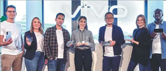  ?? PROVIDED TO CHINA DAILY ?? Employees at Vivo’s European headquarte­rs in Dusseldorf, Germany, display the company’s various smartphone models. The tech firm has filed over 2,000 patents for 5G innovation­s by the end of 2020, thanks to an R&D network across nine innovation centers.