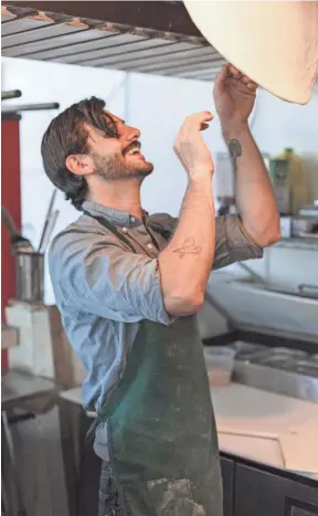  ?? PHOTOS BY CALEB KNIGHT ?? Miles Tamboli hand tosses pizza dough in his new restaurant, Tamboli Pasta & Pizza. The new Midtown Memphis dining spot is slated to open in September.