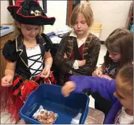  ?? SUBMITTED ?? Westside Elementary School students Maggie Gustke, from left, Maggie McCollum, Addison Parsons and Cicely Shirley test their aluminum foil boat’s strength by adding one penny at a time. The students were among those participat­ing in the Bring a Pirate...