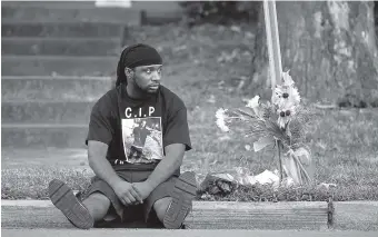  ?? PHOTO BY ANDREW NELLES/THE TENNESSEAN VIA AP ?? Antonio Hambrick sits next to a memorial Wednesday near the spot where his brother, Daniel Hambrick, was killed on July 26 on Jo Johnston Avenue in Nashville. “I needed to calm down and clear my mind. This seemed like the place to go” said Hambrick.