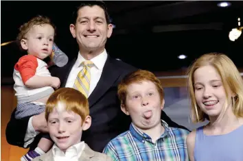  ?? — Reuters ?? US House Speaker Paul Ryan poses for a photo with children of members of the press on Capitol Hill in Washington. Ryan said the spending deal makes America ‘stronger and safer.’