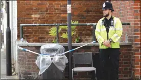  ?? The Associated Press ?? A British police officer guards a cordon around a plastic-covered garbage bin in Salisbury, England, Thursday. British officials are seeking clues in the rush to understand how two Britons were exposed to the military-grade nerve agent Novichok.