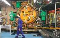  ?? REUTERS ?? A worker walks past a gas circulator in the turbine hall at EDF Energy's Hinkley Point B Nuclear Power Station in Bridgwater, southweste­rn England.