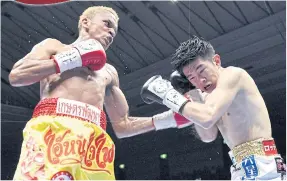  ??  ?? Amnat Ruenroeng, left, lands a left hook on Japan’s Kazuto Ioka in 2014.