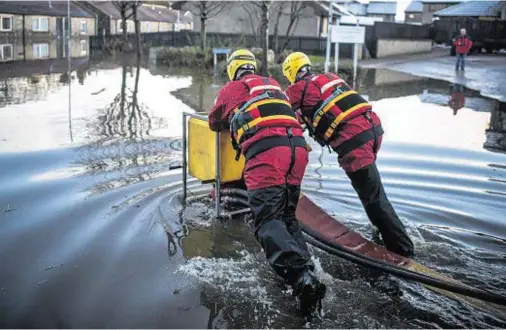  ??  ?? DELUGED: Fire crews begin to pump water from a flooded street in the Port Elphinston­e during the heavy rains