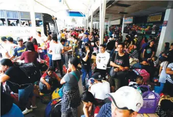  ??  ?? HOLIDAY RUSH – A dense crowd forms at the Araneta Center bBus Terminal in Quezon City as a larger volume of passengers book rides to their home provinces for the Christmas holidays. (Mark Balmores).