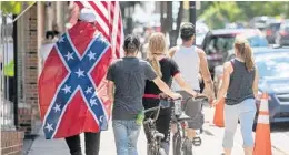  ?? ANDRE TEAGUE/BRISTOL HERALD COURIER ?? A man walking in Marion, Virginia, early this month is draped in the Confederat­e flag.