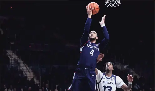  ?? AJ Mast / Associated Press ?? UConn’s Tyrese Martin (4) shoots in front of Butler’s Jayden Taylor (13) on Thursday in Indianapol­is.