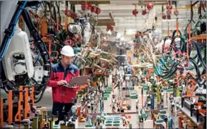  ?? PROVIDED TO CHINA DAILY ?? A worker at SAIC Motor’s Nanjing branch in Jiangbei New Area, Jiangsu province, tests equipment at the factory.