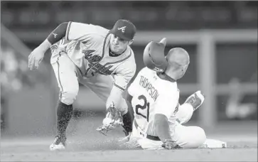  ?? Stephen Dunn Getty Images ?? TRAYCE THOMPSON of the Dodgers steals second base ahead of a throw to Atlanta Braves second baseman Chase d’Arnaud in the fourth inning. Thompson had walked leading off the inning.