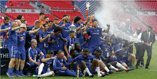  ?? — AFP ?? Chelsea coach Antonio Conte ( right) sprays champagne over his players after their FA Cup final win at Wembley in London on Saturday.