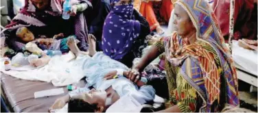  ?? File / Reuters ?? ±
Women, affected by floods, sit with their children suffering from malaria and fever, as they receive medical assistance at the Sayed Abdullah Shah Institute of Medical Sciences in Sehwan.