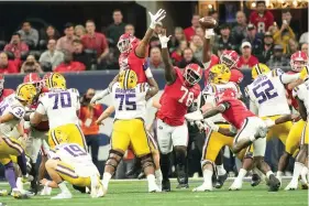  ?? (AP Photo/john Bazemore) ?? Georgia defenders Jalen Carter (88), Georgia Nazir Stackhouse (78), and Zion Logue (96) reach to block a field goal attempt by LSU place kicker Damian Ramos (34) in the first half of the Southeaste­rn Conference Championsh­ip football game Saturday in Atlanta. Georgia returned the blocked kick for a touchdown.