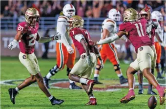  ?? AP PHOTO/COLIN HACKLEY ?? Florida State’s Jarrian Jones, center, celebrates with teammates Azareye’h Thomas, left, and Patrick Payton after intercepti­ng a Miami pass in the fourth quarter of Saturday’s game in Tallahasse­e.