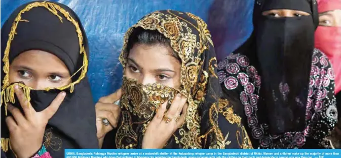  ??  ?? UKHIA, Bangladesh: Rohingya Muslim refugees arrive at a makeshift shelter at the Kutupalong refugee camp in the Bangladesh­i district of Ukhia. Women and children make up the majority of more than 600,000 Rohingya Muslims who have fled violence in...