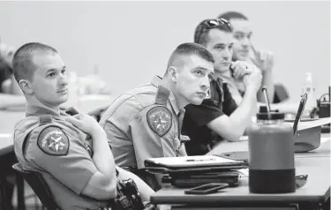  ?? Michael Wyke / Contributo­r ?? Law enforcemen­t officers listen during a class on fake temporary vehicle tags last month in Conroe.