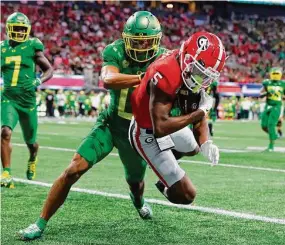  ?? Todd Kirkland/Getty Images ?? Oregon’s Christian Gonzalez attempts to make a tackle against Georgia on Sept. 3.