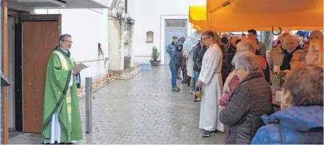  ?? FOTO: CHRISTOPH KLAWITTER ?? Pfarrer Wolfgang Drescher (links) bei der Einweihung des neuen Kirchplatz­es.