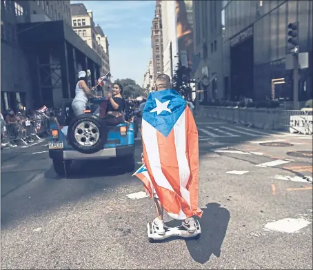  ?? THE ASSOCIATED PRESS ?? Participan­ts in today’s Puerto Rican Day Parade in New York City want people to know that the island is still struggling to recover from Hurricane Maria.