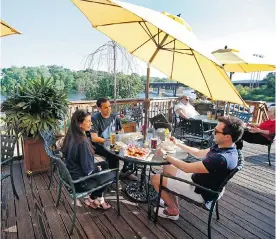  ?? PHOTOS: ELISE AMENDOLA/ THE ASSOCIATED PRESS ?? Many restaurant­s along the Merrimack River, such as the Tap Brewing Company, offer large decks for their diners to enjoy the scenic views over a cocktail or two.