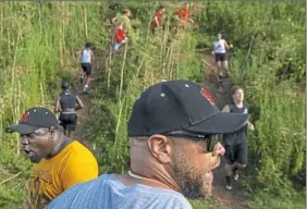  ??  ?? Northgate coach Mike Fulmore leads his team through an uphill sprinting drill they call "Team Building" during a summer practice.