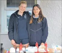  ??  ?? SPORTS ELITE: Sophie Brooke (left) and Rebecca Benge help out at the barbecue.