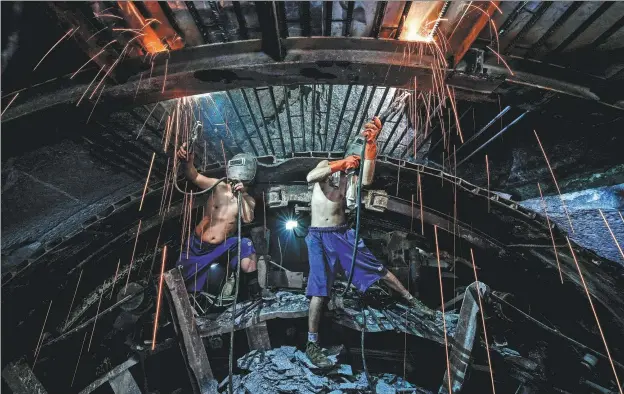  ??  ?? Above: Workers from China Railway Tunnel Group weld the connecting bars of the steel arch at the head of the tunnel borer to prevent falling rubbles, Oct 22, 2020. Below left: Workers pour concrete on the tunnel floor below ground of the Qinling Mountains in Northwest China’s Shaanxi province, Nov, 2020.