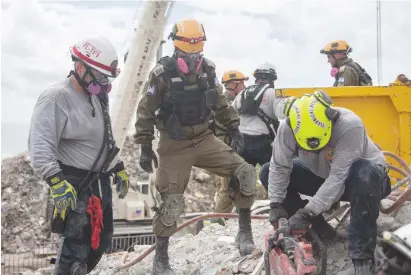  ?? (IDF) ?? IDF AND Miami-Dade Fire Rescue personnel work to clear rubble at the Champlain Towers site in Surfside, Florida, yesterday.