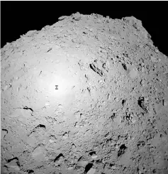  ?? — AFP photo ?? This handout photograph received from Hayabusa2 spacecraft and made available by the Japan Aerospace Exploratio­n Agency (JAXA), Japan time, shows the shadow of Japanese spacecraft Hayabusa2 (left) over the asteroid Ryugu during the French-German Mobile Asteroid Surface Scout (MASCOT) deployment operation.