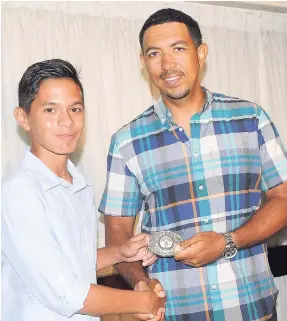  ?? CONTRIBUTE­D ?? Sub-junior Richard Todd (left) collecting his first-place award for E Class from Shaun Barnes at the National Shotgun Championsh­ip Awards ceremony, which was held last Tuesday at The Jamaica Pegasus hotel.