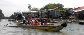  ??  ?? BOAT RIDE Volunteer teachers from Bulacan State University ride a boat to reach children in coastal communitie­s of Bulakan town who skip classes for lack of transporta­tion money.