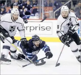  ?? Trevor Hagan Associated Press ?? THE KINGS’ Drew Doughty, right, and Derek Forbort get the best of Winnipeg’s Bryan Little during a recent game. Doughty averages nearly 27 minutes per game.