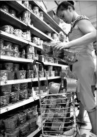  ?? GUO CHENG / XINHUA ?? A woman picks instant noodles in a supermarke­t in Haikou, Hainan province.