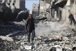  ?? HATEM ALI — THE ASSOCIATED PRESS ?? A Palestinia­n looks at the destructio­n after an Israeli strike on residentia­l buildings in Rafah, Gaza Strip, Thursday.
