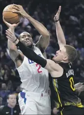  ?? Jeff Chiu Associated Press ?? CLIPPERS FORWARD Kawhi Leonard (2) is fouled by Golden State Warriors guard Donte DiVincenzo.