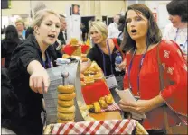  ?? Michael Quine ?? Christine Collins of Bake Crafters Food Co. points out products to Lory Hayon, registered dietitian for the Clark County School District, during the conference of the School Nutrition Associatio­n.Las Vegas Review-journal @Vegas88s