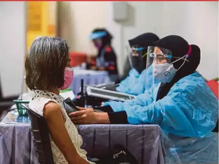  ?? PIC BY AZRUL EDHAM MOHD AMINUDDIN ?? Staff at a private hospital in Seremban asssessing the health of a senior citizen before administer­ing the Covid-19 vaccine on Tuesday.