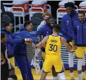  ?? TONY AVELAR — THE ASSOCIATED PRESS ?? Warriors guard Stephen Curry celebrates with teammates on the bench after he scored his career-high 62 points against the Trail Blazers on Sunday.