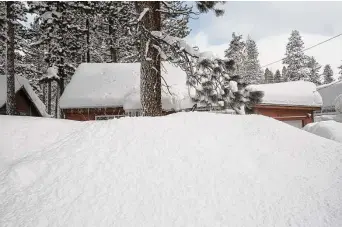  ?? Salgu Wissmath/Associated Press ?? Residentia­l properties peek out behind several feet of snow along Larch Avenue on Wednesday in South Lake Tahoe, Calif.