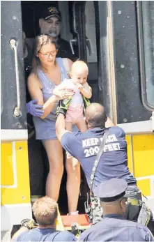  ??  ?? PRECIOUS CARGO: Emergency workers help passengers off an LIRR train near the Queens Village station Saturday after an MTA worker was fatally struck on the tracks.